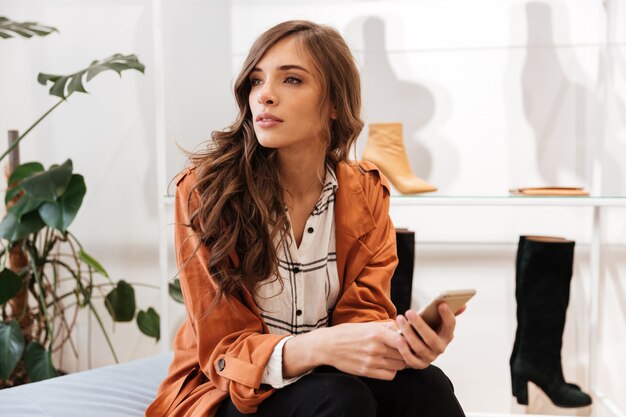 Portret van een jonge vrouw die mobiele telefoon houdt