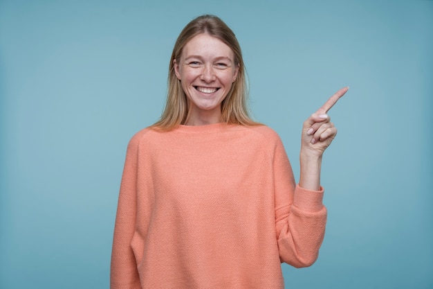 Gratis foto portret van een jonge vrouw die naar iets wijst