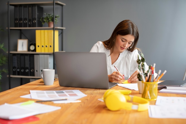 Portret van een jonge vrouw die op haar laptop werkt bij een startend bedrijf