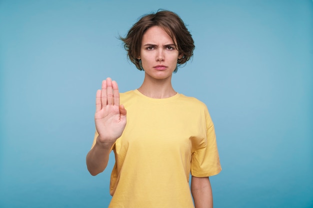 Portret van een jonge vrouw die stop toont met haar hand