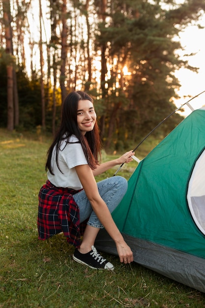 Gratis foto portret van een jonge vrouw die tent bevestigt