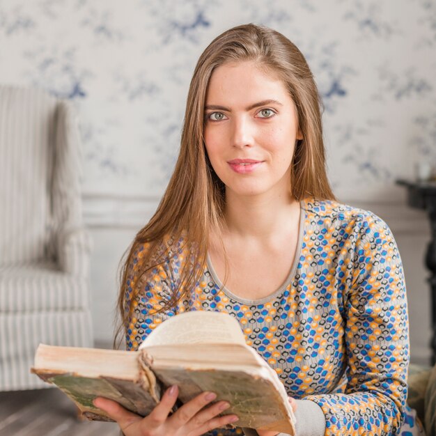 Portret van een jonge vrouw die uitstekend boek leest