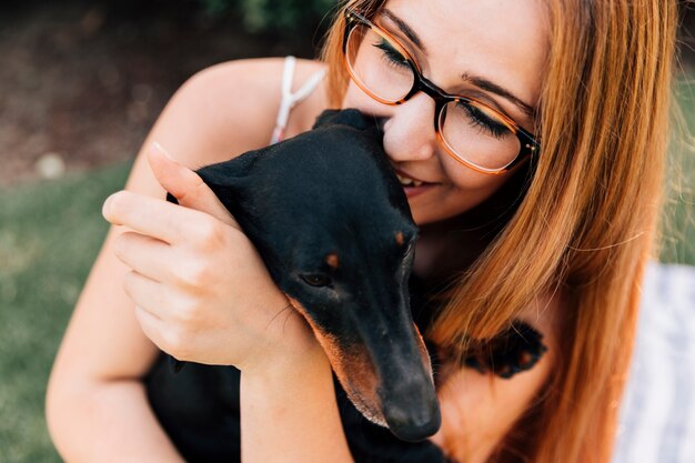 Portret van een jonge vrouw die van haar hond houdt
