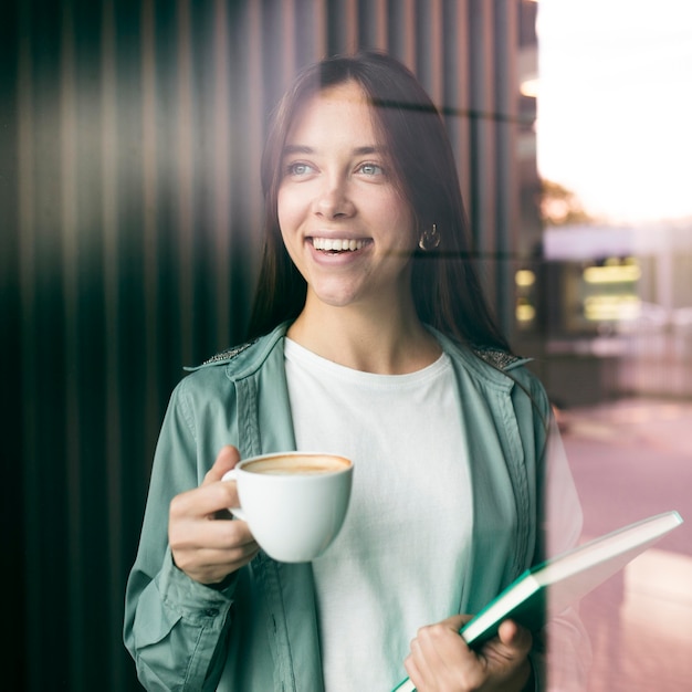 Portret van een jonge vrouw die van koffie geniet