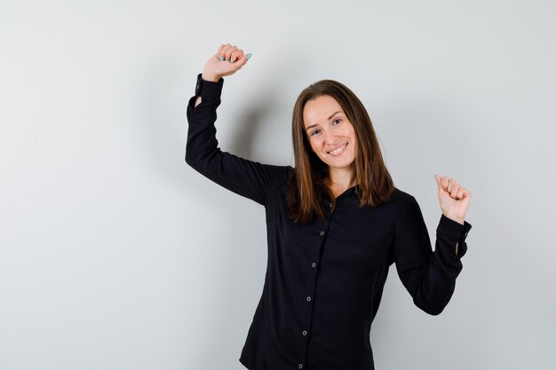 Portret van een jonge vrouw die winnaargebaar toont