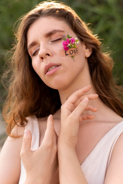 Portret van een jonge vrouw die zelfverzekerd buiten poseert met bloemen