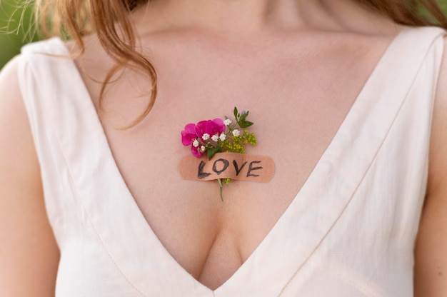 Portret van een jonge vrouw die zelfverzekerd buiten poseert met bloemen