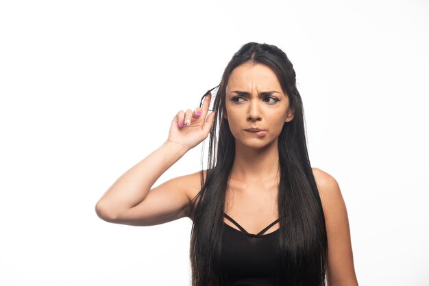 Portret van een jonge vrouw die zich voordeed op een witte muur