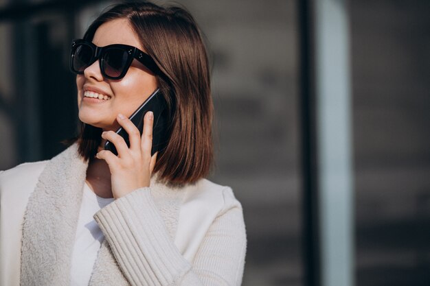 Portret van een jonge vrouw in de stad met behulp van de telefoon