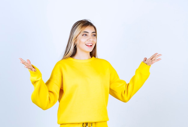 Portret van een jonge vrouw in gele outfit poseren en staan