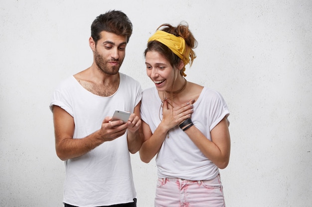 Portret van een jonge vrouw kijken naar foto's op de mobiele telefoon