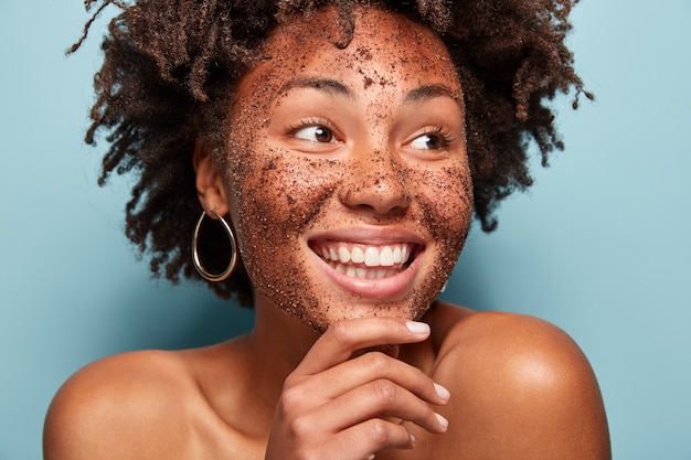 Portret van een jonge vrouw met Afro-kapsel en gezichtsmasker