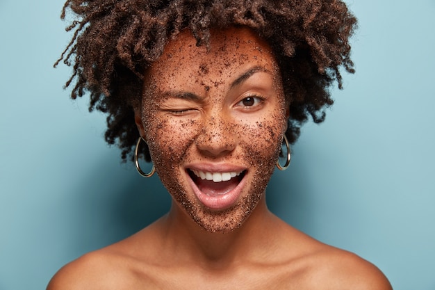 Gratis foto portret van een jonge vrouw met afro-kapsel en gezichtsmasker