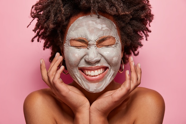 Portret van een jonge vrouw met Afro-kapsel en gezichtsmasker