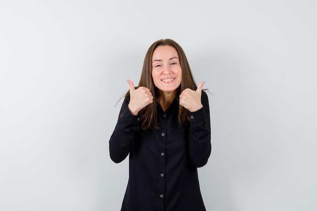 Portret van een jonge vrouw met dubbele duimen omhoog