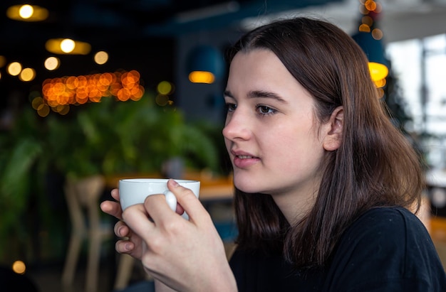 Portret van een jonge vrouw met een kopje thee in een café