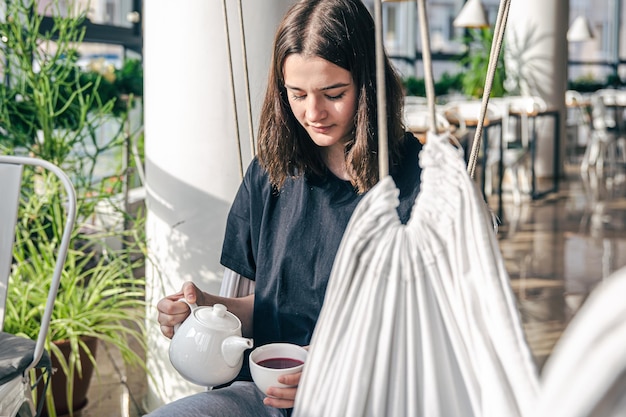 Portret van een jonge vrouw met een kopje thee in een café