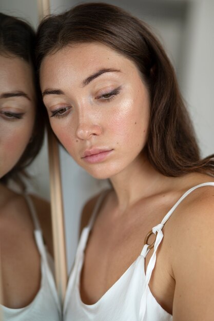 Portret van een jonge vrouw met een laag zelfbeeld met spiegel