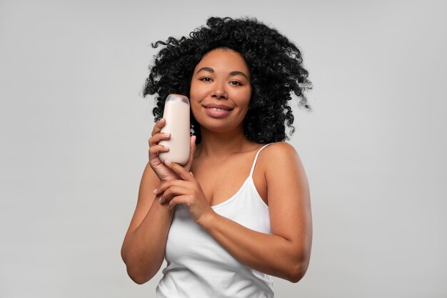 Portret van een jonge vrouw met fles bodylotion