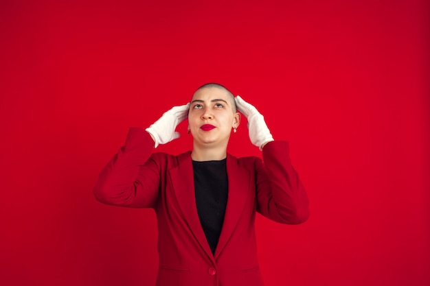 Portret van een jonge vrouw met freaky uiterlijk op rode muur