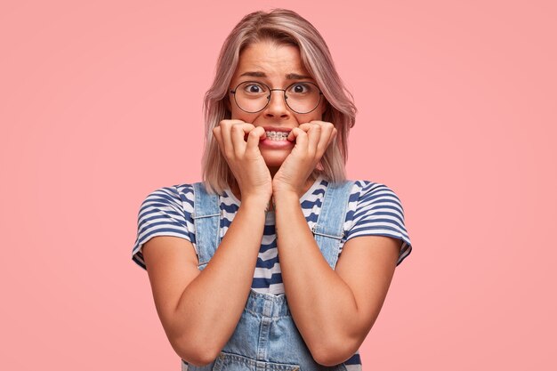 Portret van een jonge vrouw met gekleurd haar dat een overall draagt