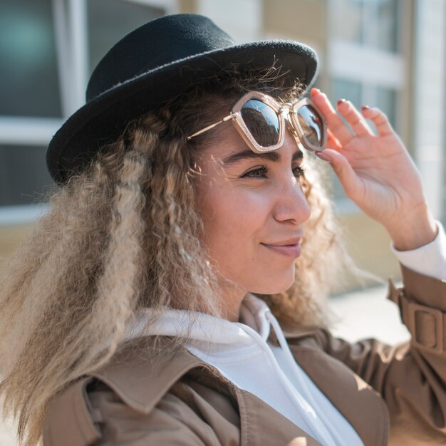 Portret van een jonge vrouw met hoed en zonnebril