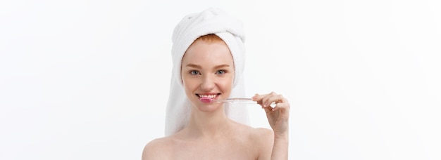 Gratis foto portret van een jonge vrouw met tandenborstel op grijze achtergrond