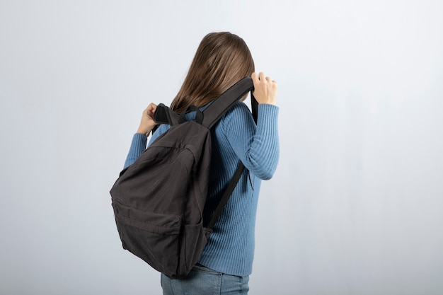 Portret van een jonge vrouw model permanent met rugzak en poseren.