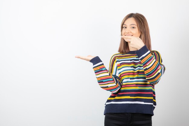 Portret van een jonge vrouw model wijzend bij de hand.