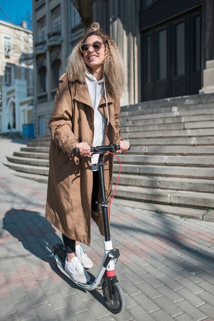 Portret van een jonge vrouw op elektrische scooter