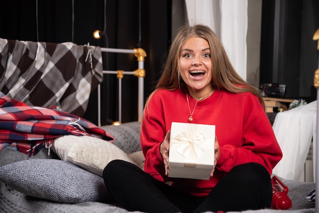 Portret van een jonge vrouw poseren met geschenkdoos.