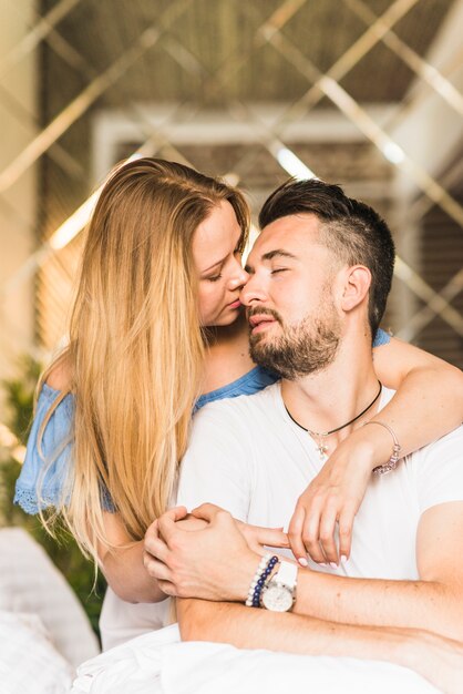 Portret van een jonge vrouw zoenen man teder op de neus