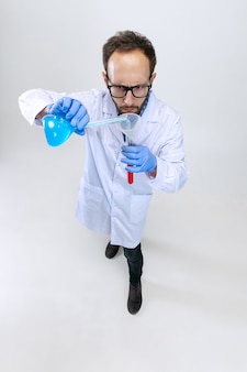 Portret van een jonge wetenschapper, chemicus of arts voert chemisch onderzoek uit in een farmaceutisch laboratorium.