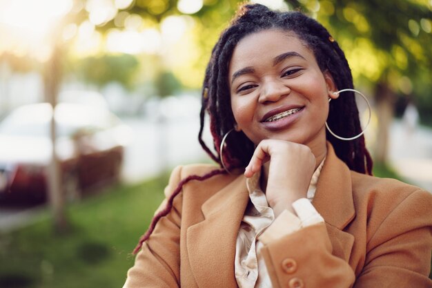 Portret van een jonge zwarte vrouw die in een straat staat