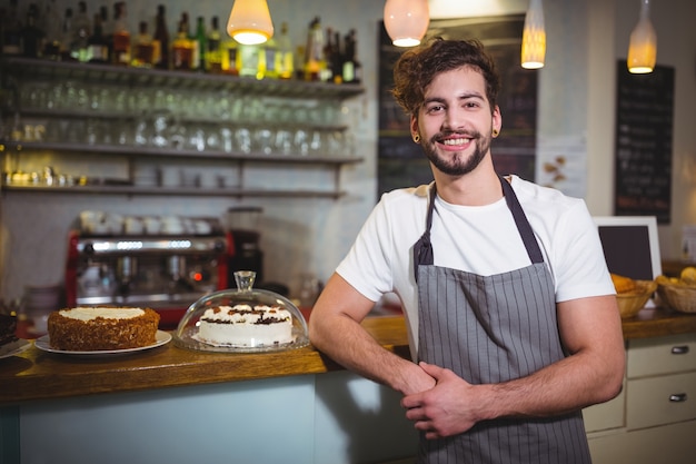 Portret van een kelner die zich bij teller