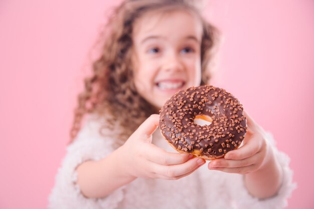 Portret van een klein glimlachend meisje met donuts