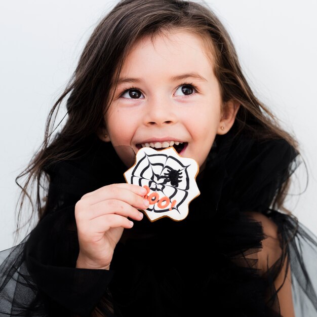 Portret van een klein meisje dat een koekje eet