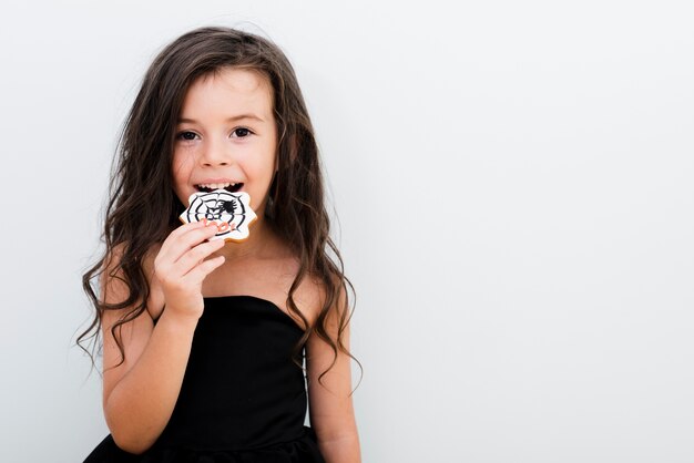 Portret van een klein meisje dat een koekje eet