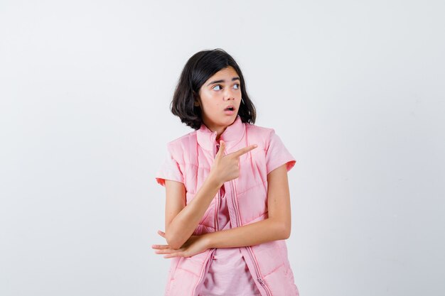 Portret van een klein meisje in wit t-shirt en kogelvrij vest dat naar rechts wijst