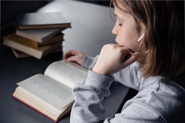 Portret van een klein meisje met een boek, een kind leest een boek