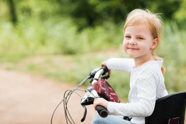 Gratis foto portret van een klein meisje op de fiets