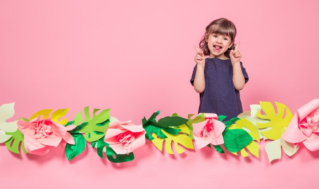 Portret van een klein meisje op een zomer roze achtergrond