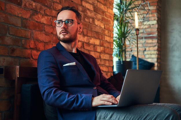 Portret van een knappe, bebaarde man die vintage zakelijke kleding draagt