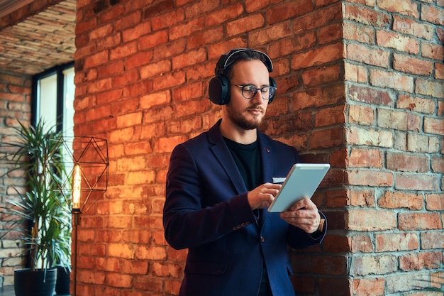 Portret van een knappe, bebaarde man in een stijlvol pak listeni