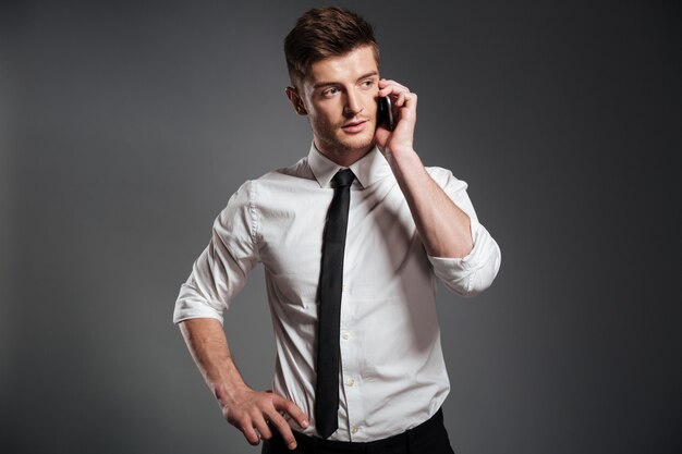Portret van een knappe jonge zakenman praten op mobiele telefoon