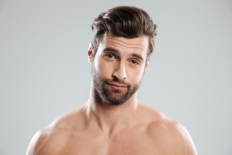 Gratis Foto portret van een knappe twijfelachtige man met blote schouders