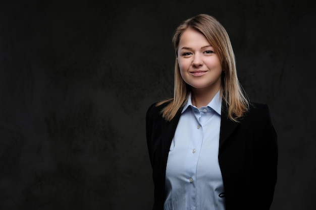 Portret van een lachende blonde zakenvrouw formeel gekleed. Geïsoleerd op een donkere gestructureerde achtergrond.