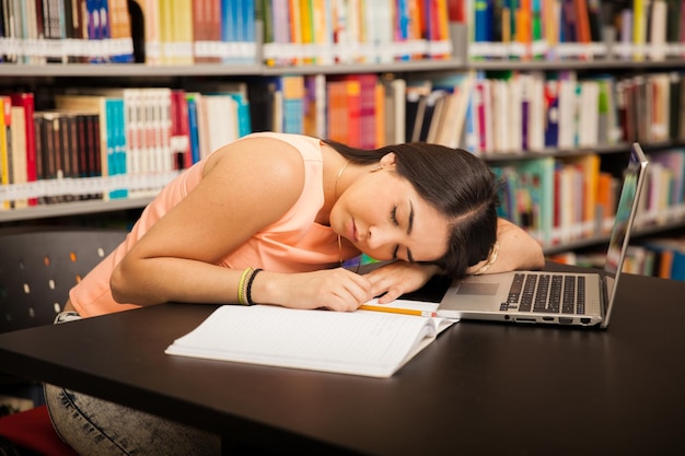 Portret van een Latijnse student die zich moe en overweldigd voelt op school en een dutje doet