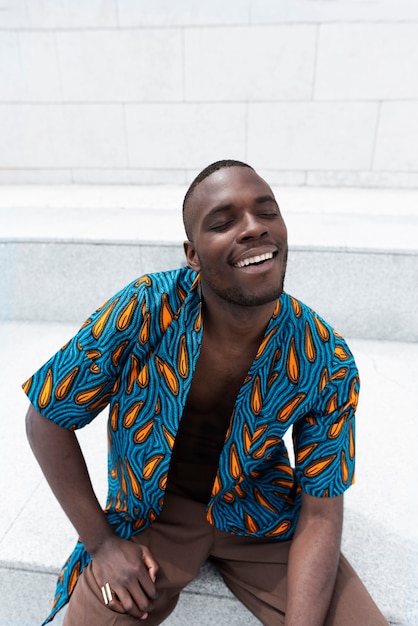 Gratis foto portret van een man die zich voordeed in traditionele afrikaanse kleding buiten