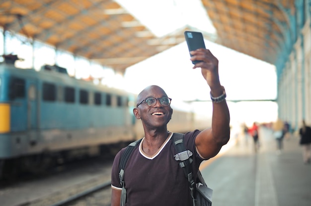 portret van een man in een treinstation terwijl hij een selfie maakt